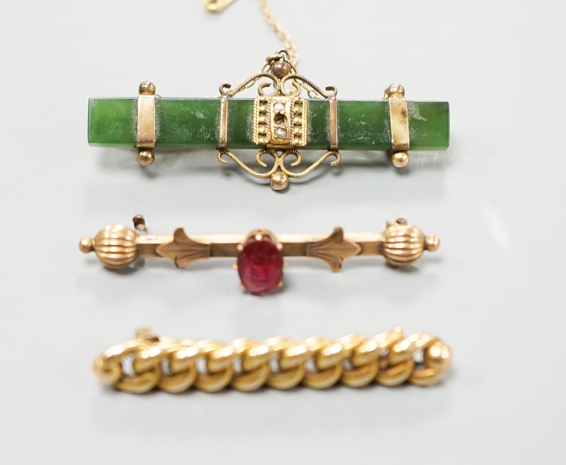 An Edwardian 15ct interwoven bar brooch, 45mm gross 4.2 grams, a mounted nephrite bar brooch and one other bar brooch.